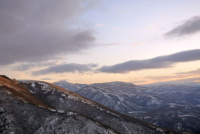 Scenic view of snowcapped mountains against sky during sunset