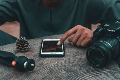 Midsection of man photographing with mobile phone