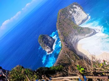 Rock formation in sea against blue sky