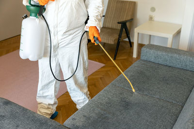 Low section of man with woman standing on floor at home