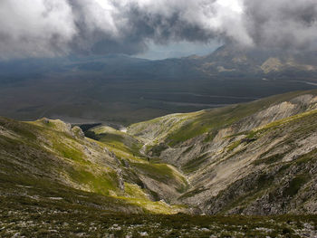 Scenic view of mountains against cloudy sky at dusk