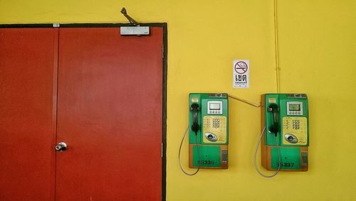 Pay phones on yellow wall