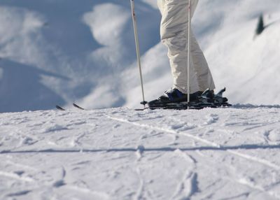 Low section of man on snow against sky