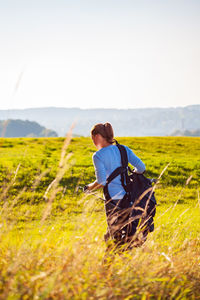 Rear view of woman walking at golf course