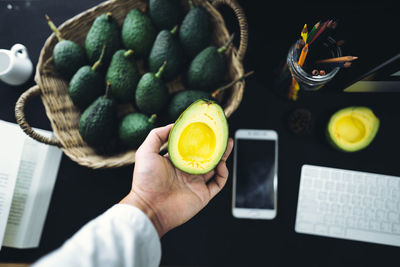 Cropped hand holding avocado