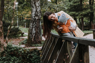 Woman with child standing by plants in forest