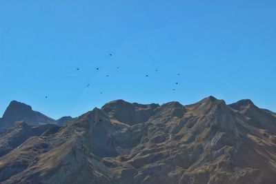 Low angle view of mountains against clear blue sky