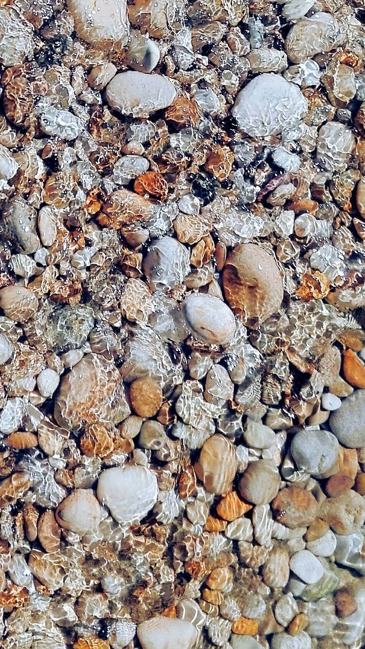 HIGH ANGLE VIEW OF STONES ON PEBBLES