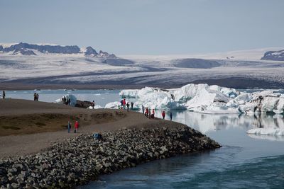 People on beach against clear sky