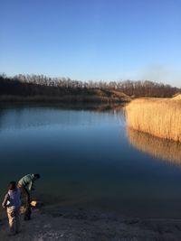 People in lake against sky