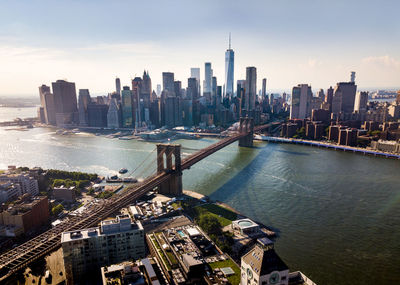 Aerial view of brooklyn bridge over river in city against sky