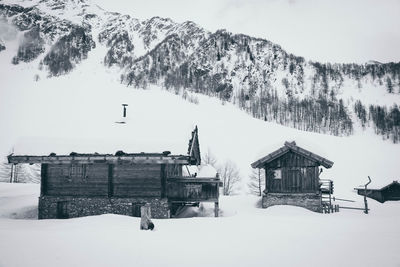 Houses on snow covered landscape against sky