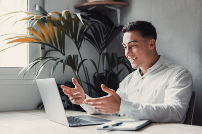 Young man using laptop at table