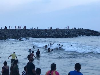 People on beach against sky