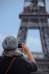 Woman photographing eiffel tower