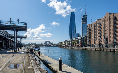 Bridge over river in city against sky