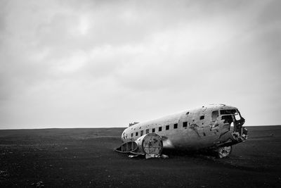 Abandoned airplane on runway against sky