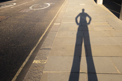 High angle view of man with shadow on road