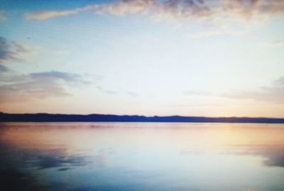 Scenic view of lake against sky at sunset