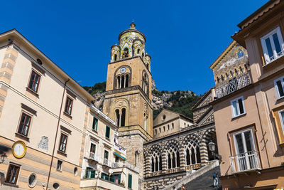 Low angle view of buildings against blue sky in amalfi, italy