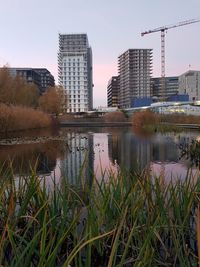 Lake in city against sky