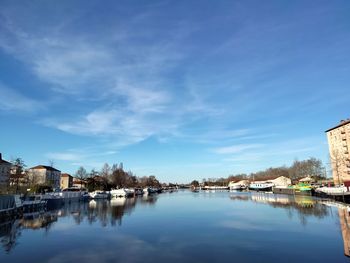 River amidst houses and buildings against blue sky