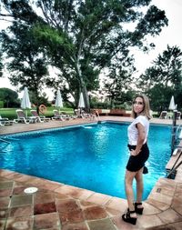 Full length of young woman standing in swimming pool