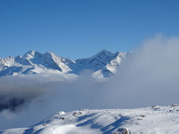 Scenic view of snowcapped mountains against clear blue sky