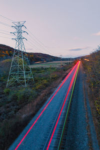Railroad tracks by road against sky