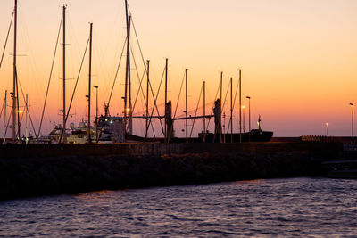 Silhouette sailboats on sea against sky during sunset