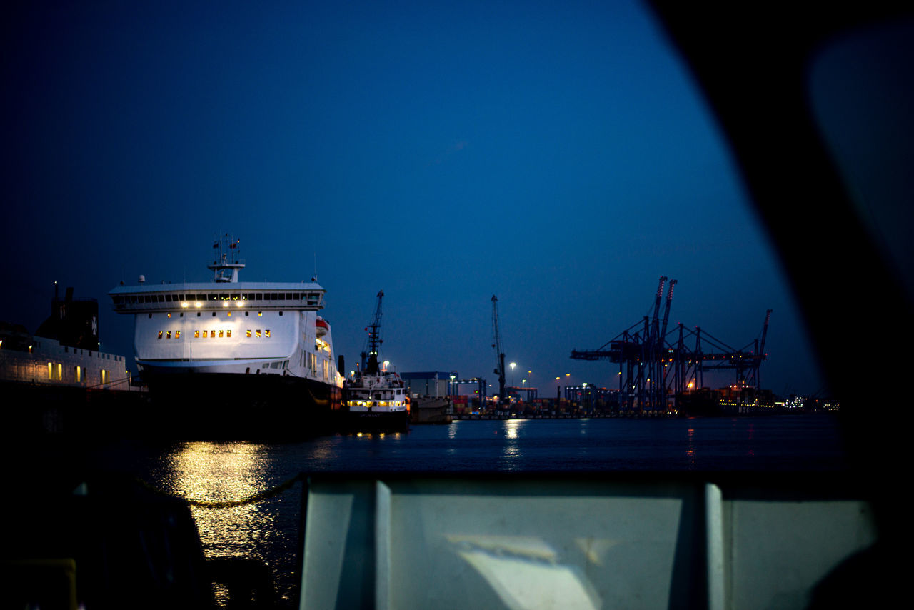 ILLUMINATED HARBOR AGAINST SKY AT NIGHT