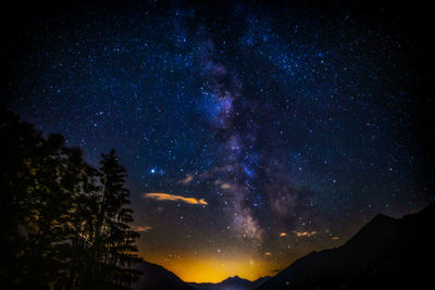 Low angle view of silhouette mountain against sky at night