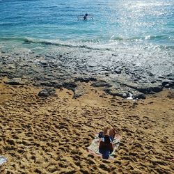 High angle view of people sitting on beach