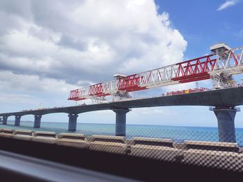 Low angle view of bridge over sea against sky