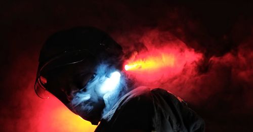 Close-up portrait of man in illuminated nightclub