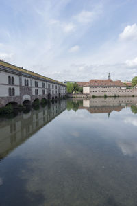 Reflection of built structure in water against sky