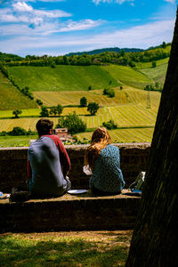 Rear view of people looking at farm