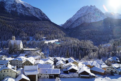 Aerial view of townscape and mountains against sky