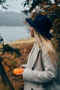 Portrait of woman holding pumpkin during autumn