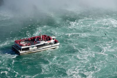 High angle view of people standing in boat on sea