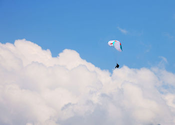 Low angle view of person paragliding against sky