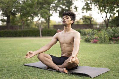 Young man sitting on grass