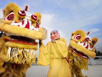 Man in costume amidst toys against sky