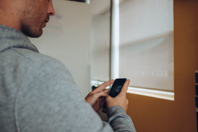 Midsection of man using mobile phone