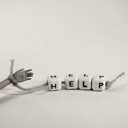 Close-up of hand using smart phone against white background