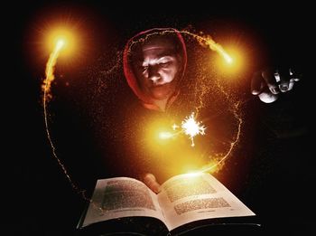 Digital composite image of man reading book at night