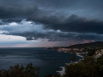 Scenic view of sea against storm clouds