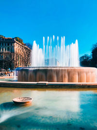 A fountain of water in front of piazza castello sforzesco aka fontana di piazza castello