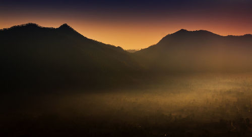 Scenic view of silhouette mountains against sky during sunset