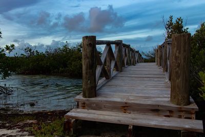 Wooden pier over lake against sky